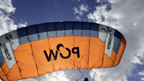 Used Flysurfer POW 4.0m parawing flying, orange canopy against a blue sky